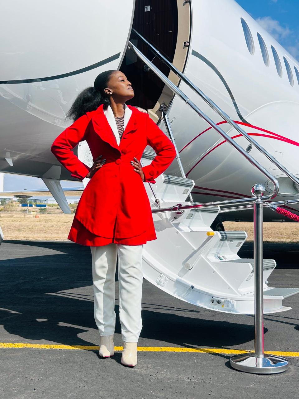 Neo Porscha Makgale, Founder and President of Flynia, standing at aircraft stairs